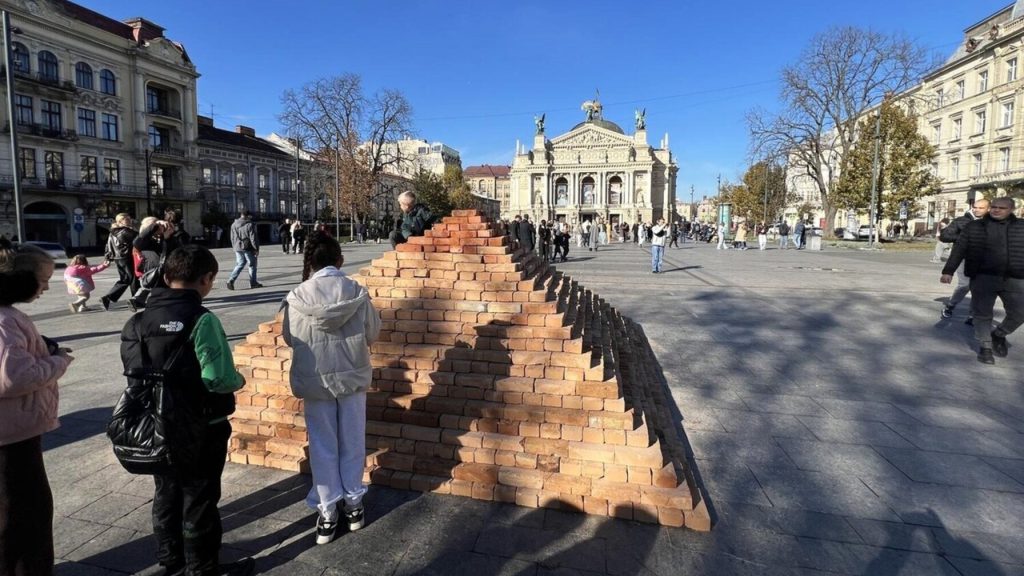 символічна сцена з пірамідою зі складених цеглин на площі