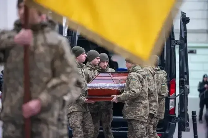 складений прапор, шолом і берці на столі