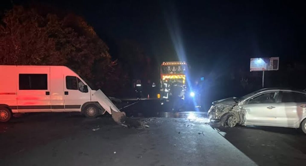 Крупний план пошкоджених легковика та мікроавтобуса на сільській дорозі в сутінках, без людей і логотипів