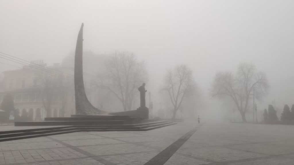 Символічна туманна вечірня вулиця Львова з фарами та світловідбивачем