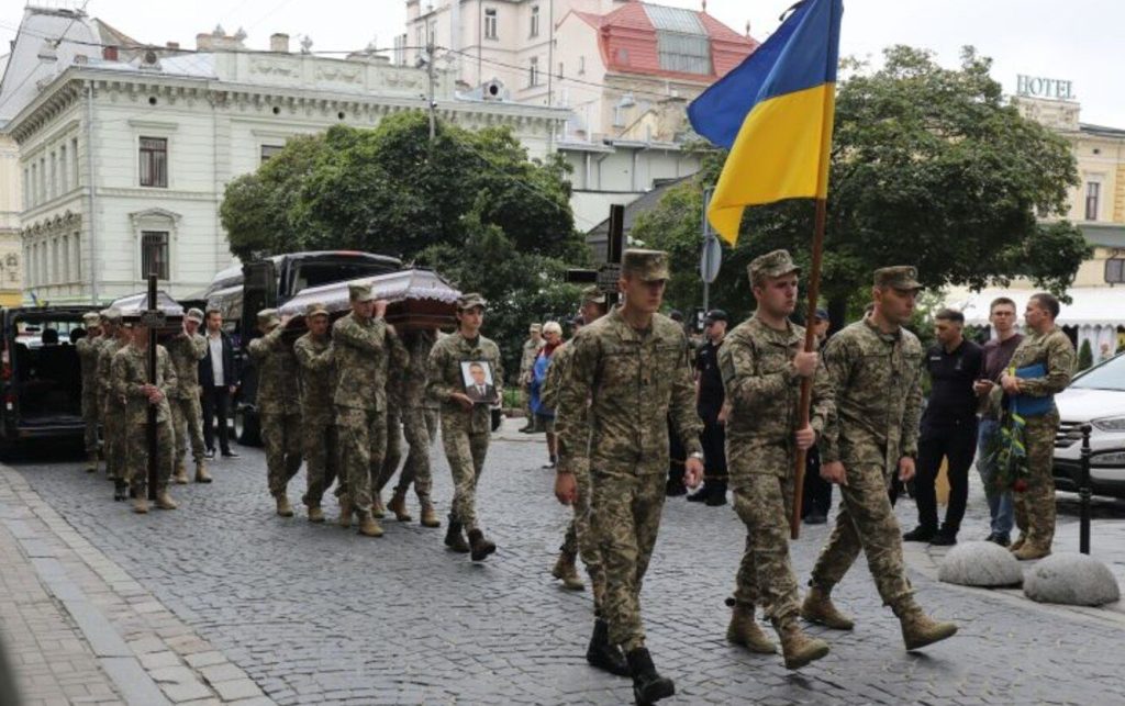 символічна натюрморт зі складеною каскою, жетонами, свічкою і букетом польових квітів