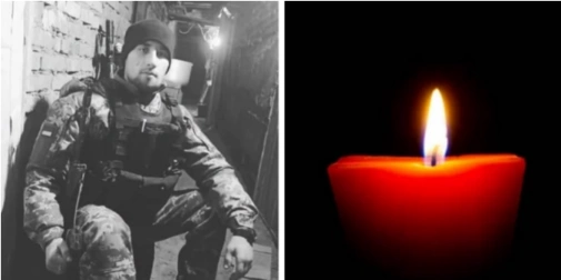 Складений прапор, шолом і червона гвоздика на дерев'яному столі