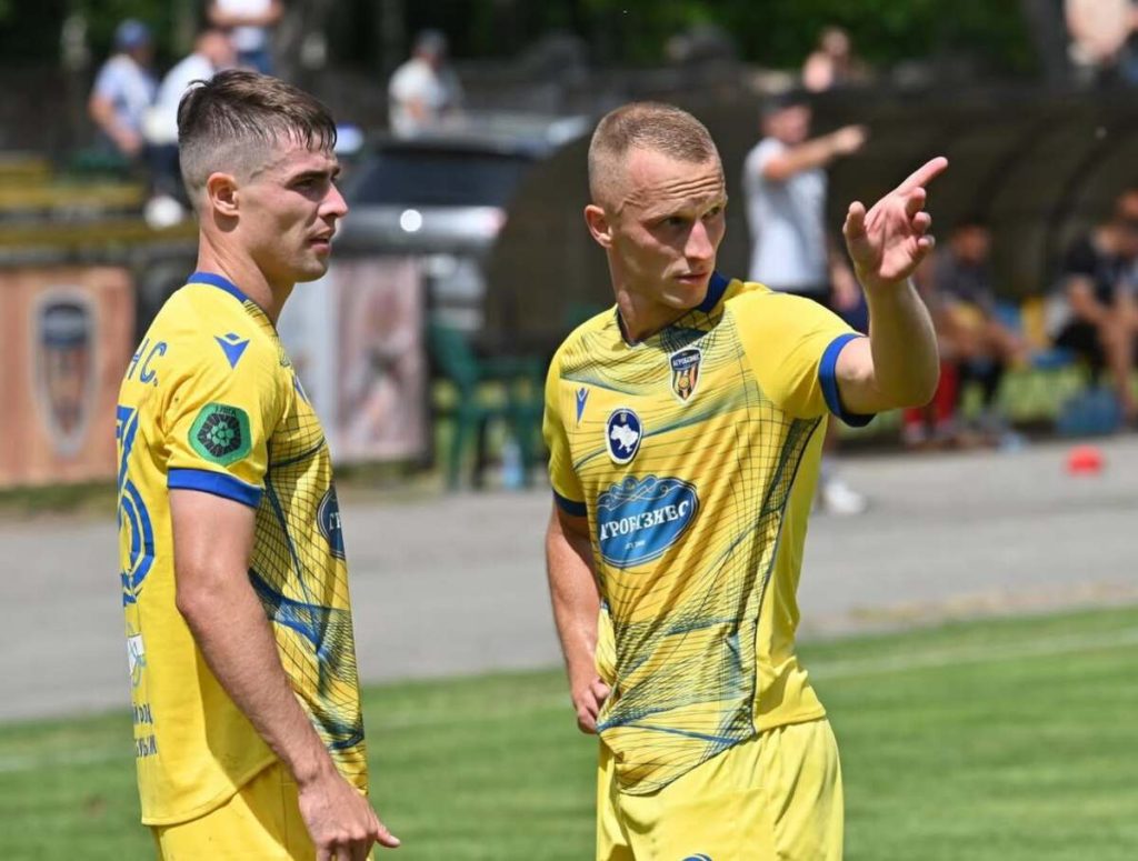Мінімалістична футбольна сцена: м’яч біля кутового прапорця, порожні трибуни без людей
