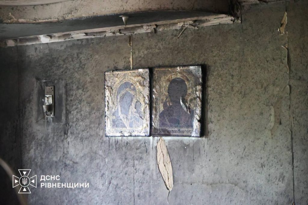 символічна сцена: багатоквартирний будинок увечері з димом на горизонті та пожежною машиною, без осіб і логотипів