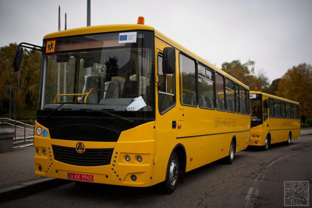 два шкільні автобуси біля сільської школи з підйомниками, без людей