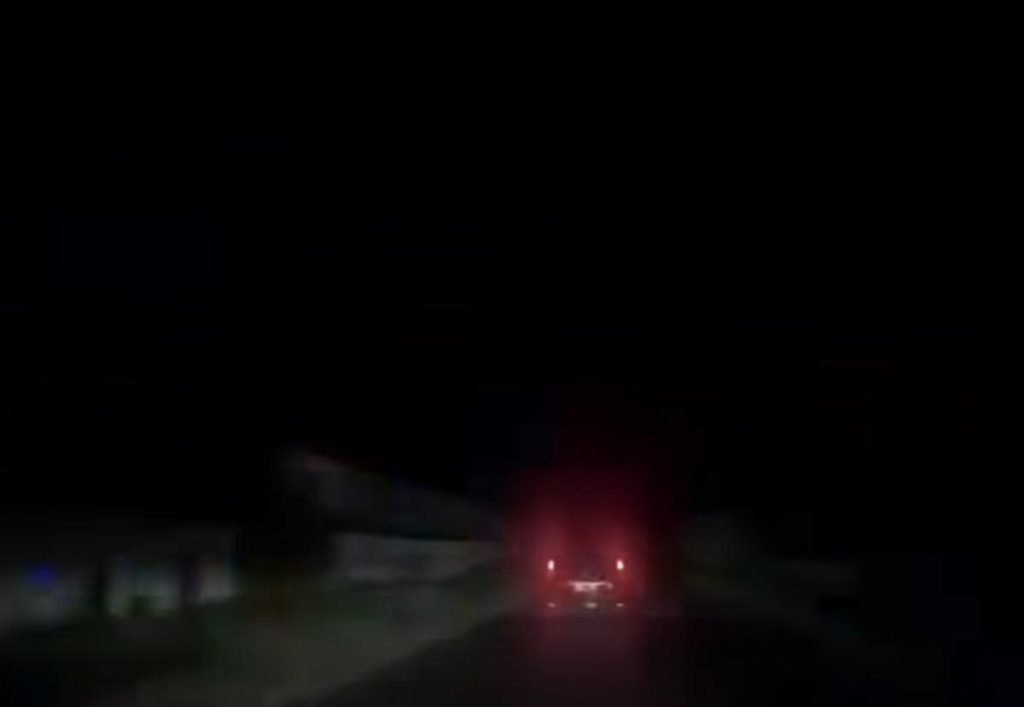 силует припаркованого авто на трасі та кайданки на узбіччі при сутінках