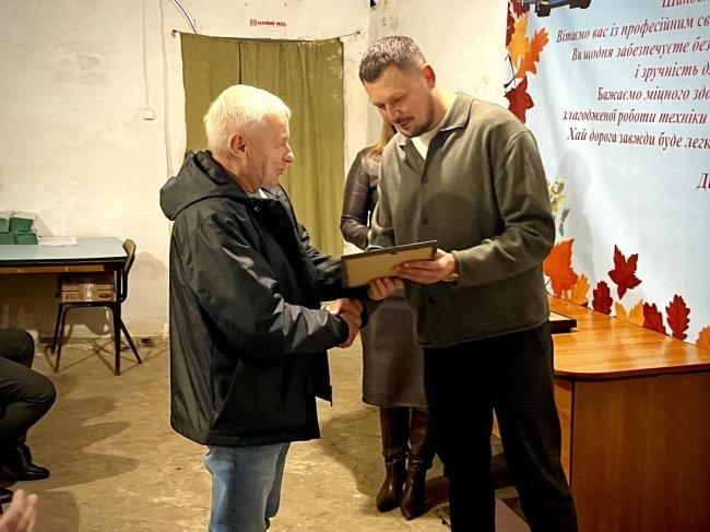 композиція з предметів транспорту і дорожнього ремонту: жилет, конус, ключ і мініатюрний автобус
