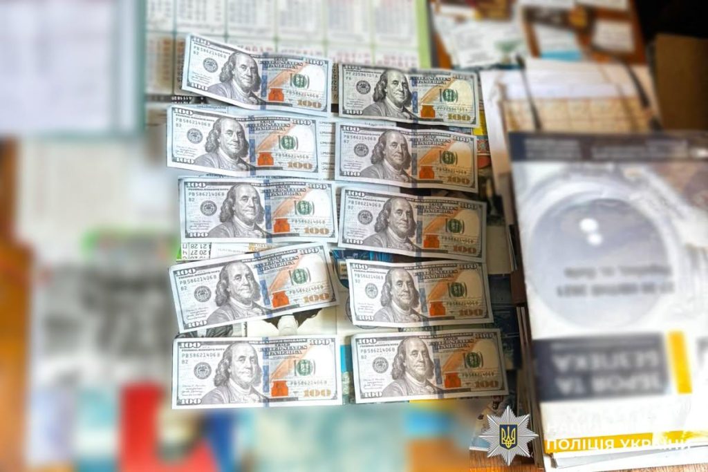 Символічна сцена: документи для вступу, ноутбук і кілька доларів на столі