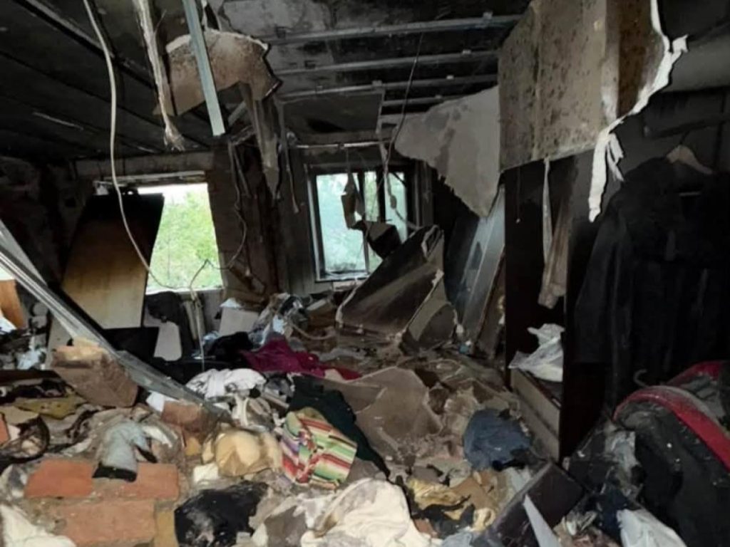 порожні дитячі черевики поруч із пледом і гаманцем на нейтральному фоні