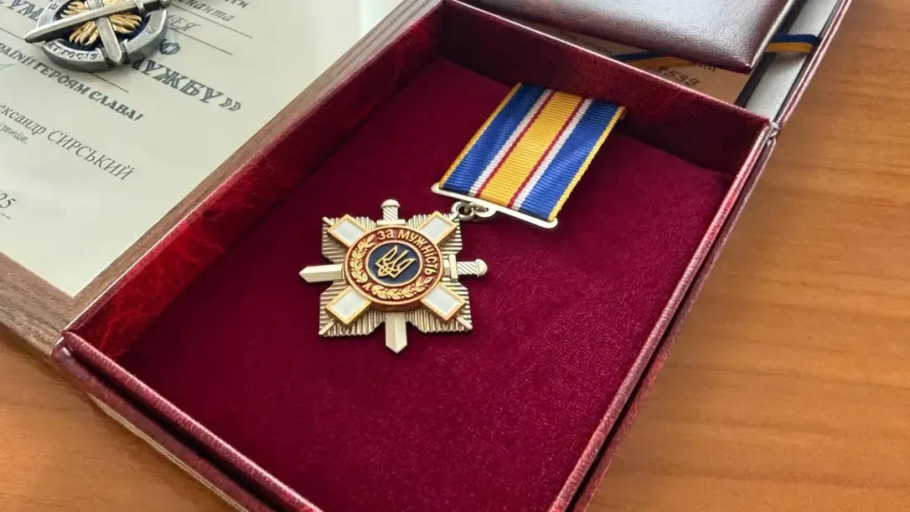 символічна композиція медалей і військових предметів на столі