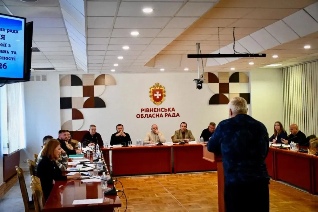 Модель будинку поруч із сонячною панеллю та монетами на столі