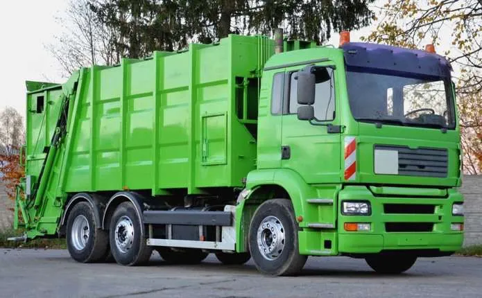 символічна сцена з контейнером для сміття, силуетом сміттєвоза і рахунком на столі