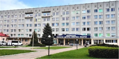 куточок лікарняної палати з радіатором, пледом і дровами, без людей