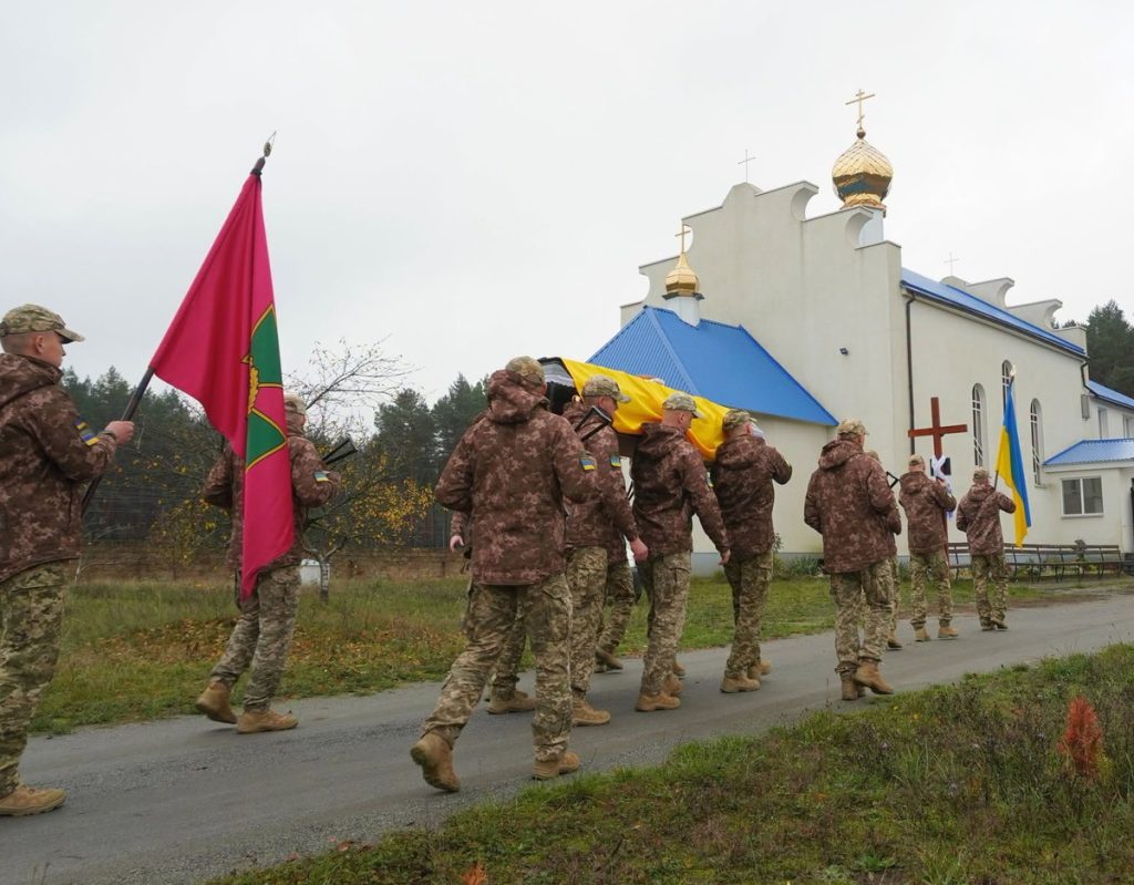 символічна натюрмортна сцена: чотири медальйони, запалена свічка і букет пшениці