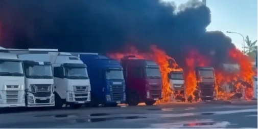 вантажівка біля будинків і школи, вогнегасник і конус на передньому плані