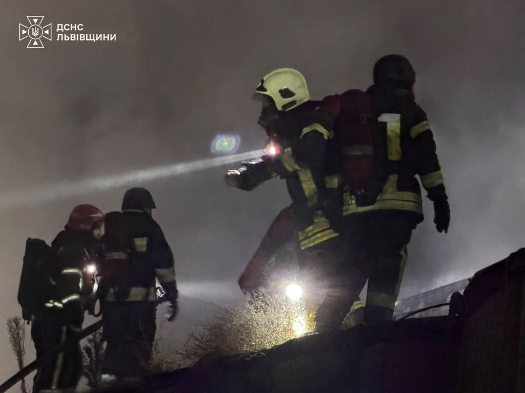 Нічна сцена пошкодженого підприємства з рятувальниками і уламками, без впізнаваних облич