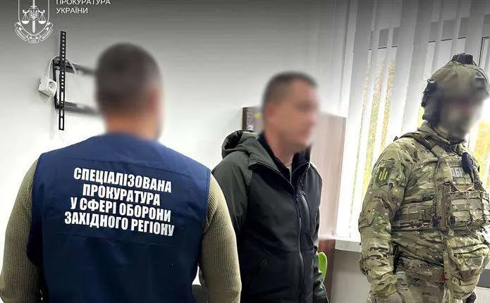 символічне фото: стіл з документами військкомату, молотком і згорнутим прапором, без людей