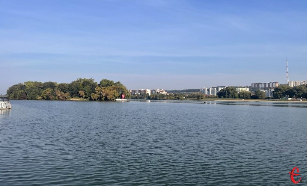 кава в гуртку, шарф і термометр серед осіннього листя на столі