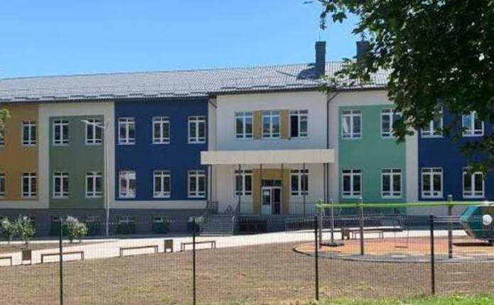 символічна сцена: модель школи, документи й ручка на столі