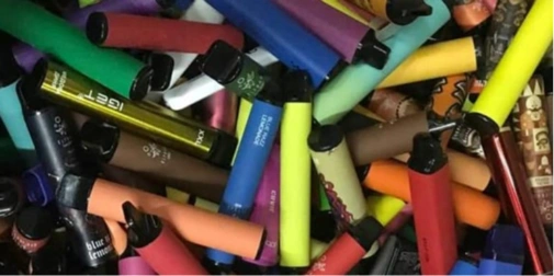вейп-прилад, флакон рідини та блокнот на деревʼяному столі