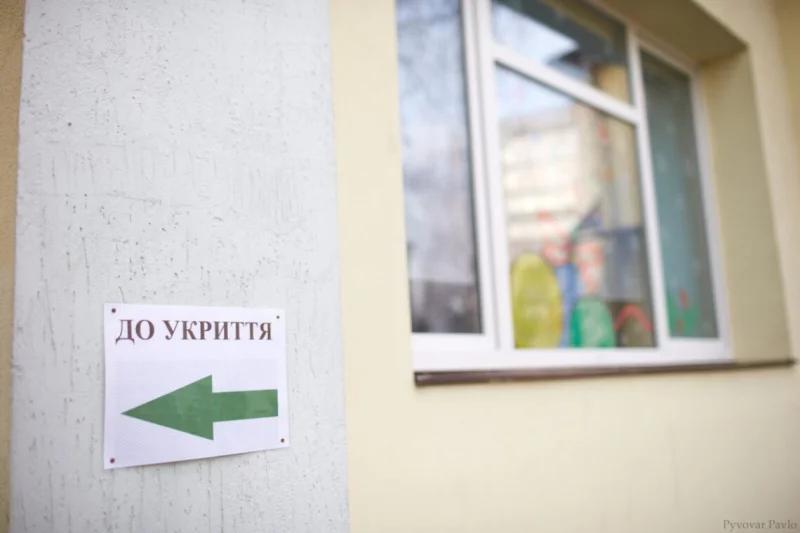символічна сцена з дверима укриття, домофоном і телефоном, без людей