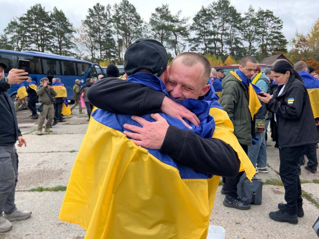 символічна предметна сцена зі складеним прапором України, військовими черевиками і листом