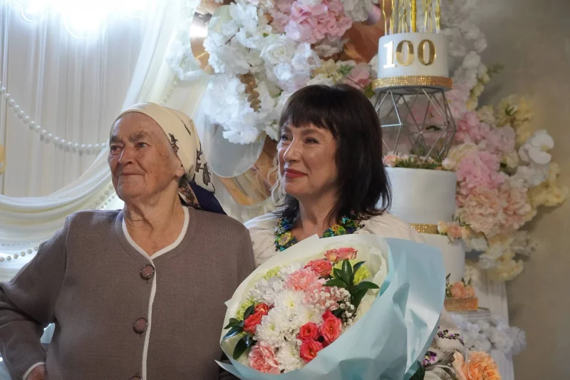 символічна сцена з фотографією, рукавичками, квітами й конвертом без тексту